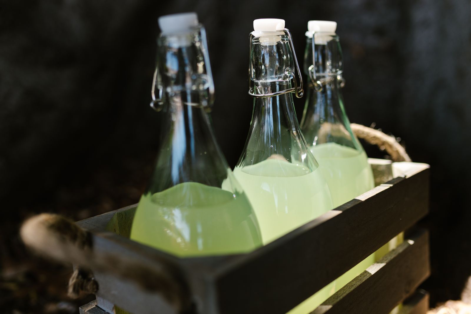 Bouteilles de limonade artisanale à bouchon mécanique dans une caisse en bois